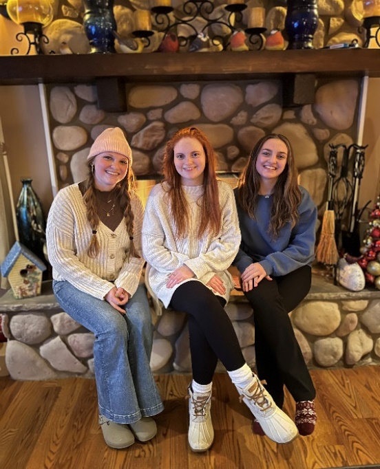 A group of women sitting on a benchDescription automatically generated with medium confidence